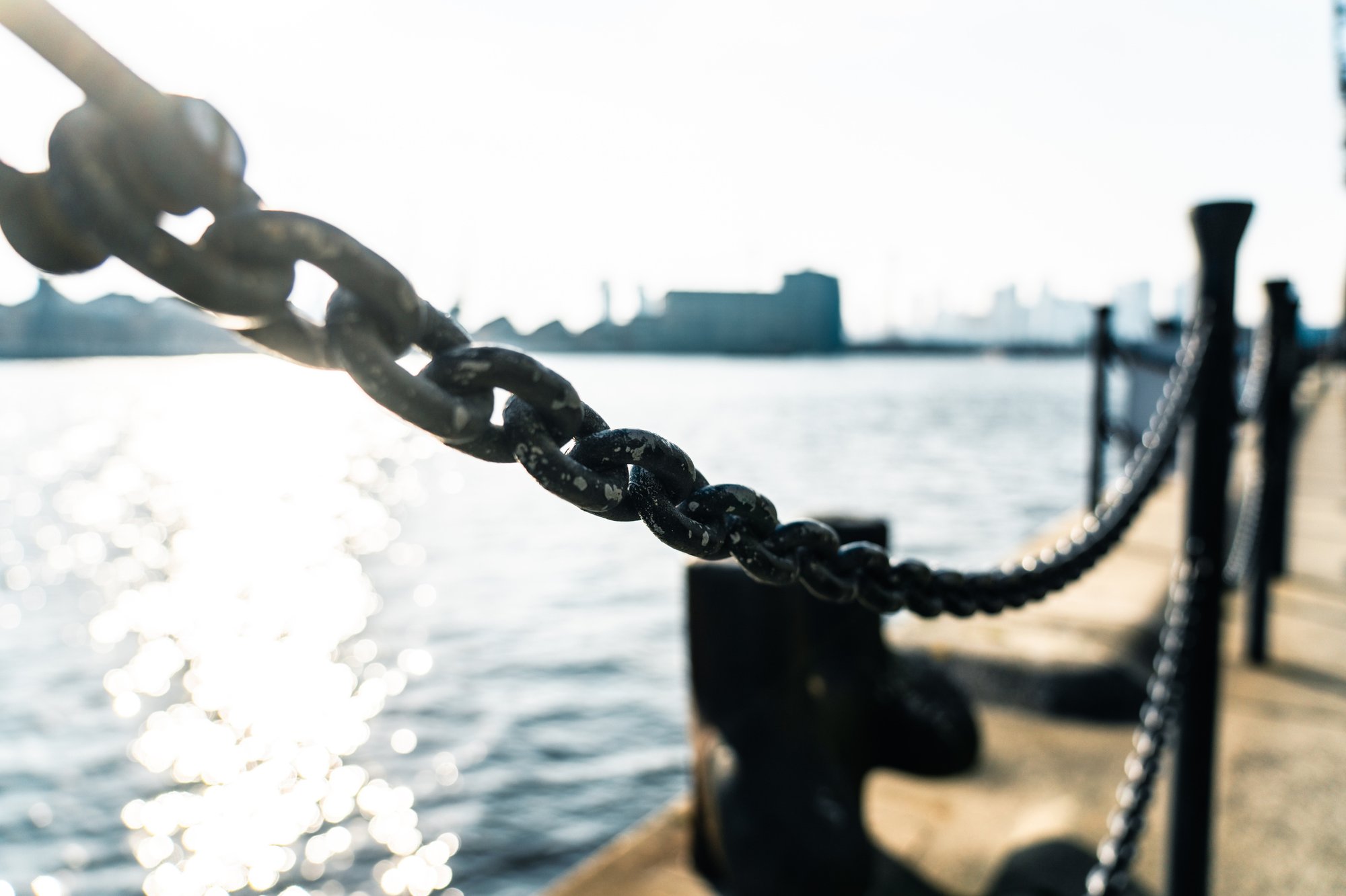 Chain link at dockside, representing the connected links of a global supply chain